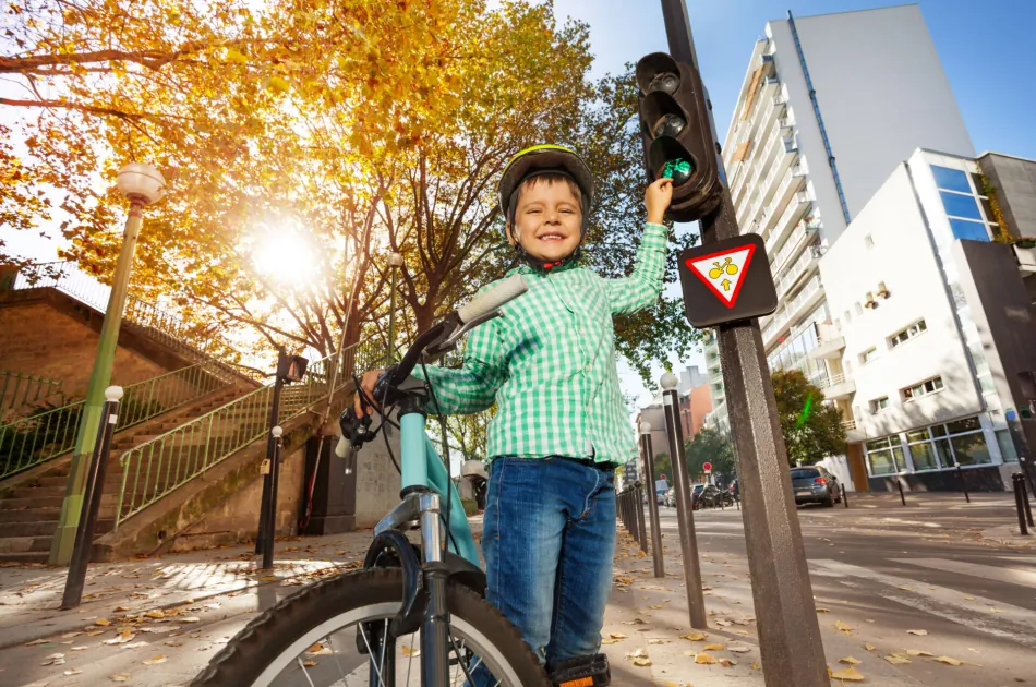 Kind mit Fahrrad an einer Ampel