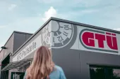 Kundin vor einer GTÜ-Prüfstelle